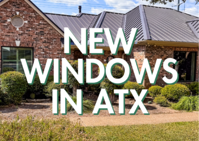 A brick house with a metal roof featuring text overlay "NEW WINDOWS IN ATX" indicating recently installed windows in Austin, Texas.